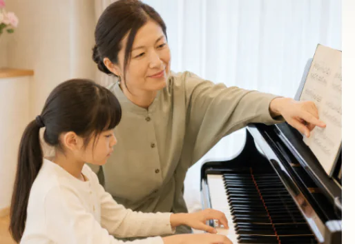 山本有紀子先生が生徒に楽譜を示しながら指導するレッスン